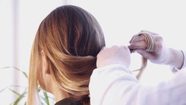 Στυλίστας μαλλιά δημιουργώντας ένα χτένισμα για μια όμορφη γυναίκα στο σαλόνι — Αρχείο Βίντεο