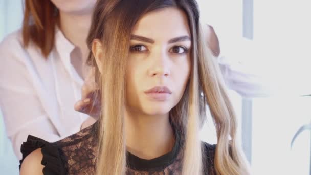 Стиліст волосся створює зачіску для красивої жінки в салоні краси — стокове відео