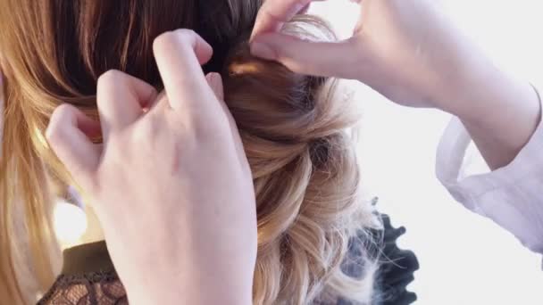 Перукар створює зачіску для красивої жінки в салоні — стокове відео