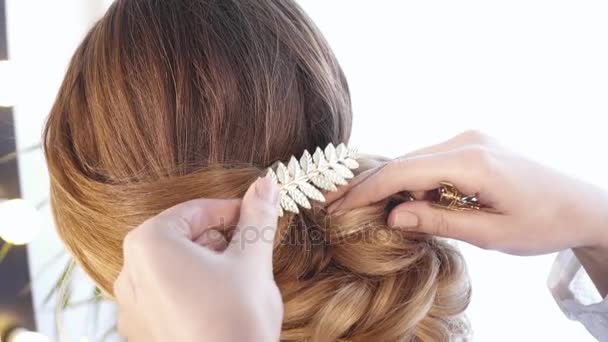 Hair stylist creating a hairstyle for a brunette woman view from back — Stock Video