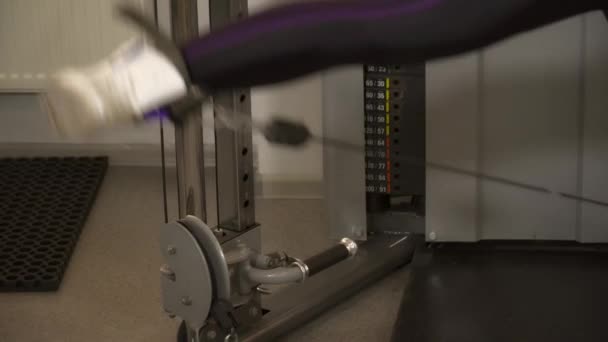 Jeune femme formant ses jambes sur le câble et poulie machine gros plan 