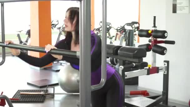 Young woman stretching in the gym, stroking legs — Stock Video