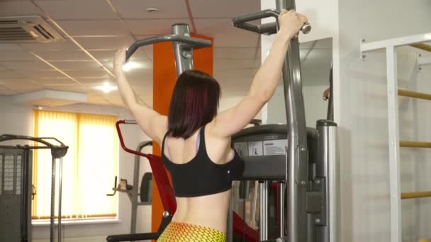 Mujer joven haciendo las flexiones en el gimnasio — Vídeo de stock