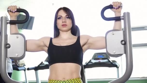 Joven hermosa mujer entrenando en la máquina de cubierta pec — Vídeos de Stock