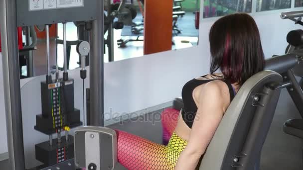 Young woman training on the leg adduction, abduction machine — Stock Video