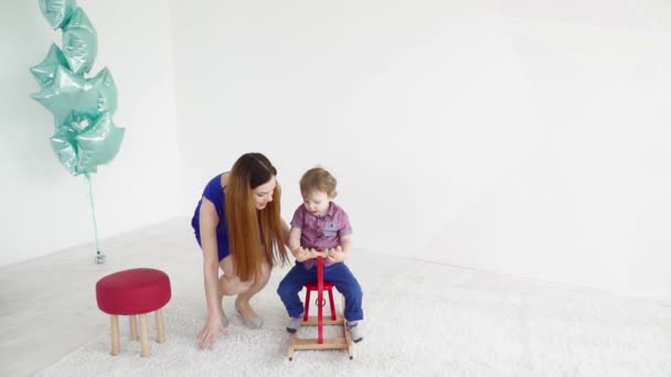 Молодая мать играет со своим маленьким сыном замедленной съемки — стоковое видео