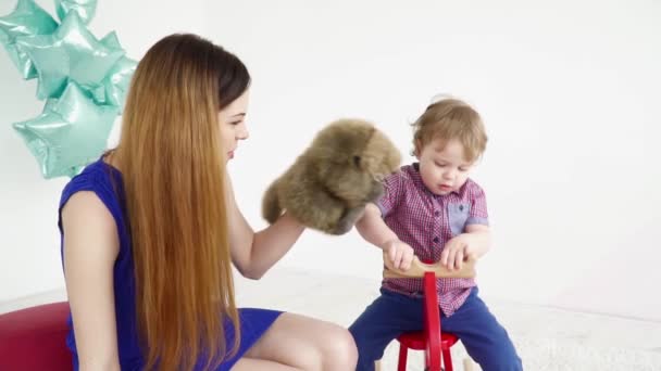 Jovem mãe brincando com seu filho pequeno com o brinquedo câmera lenta — Vídeo de Stock