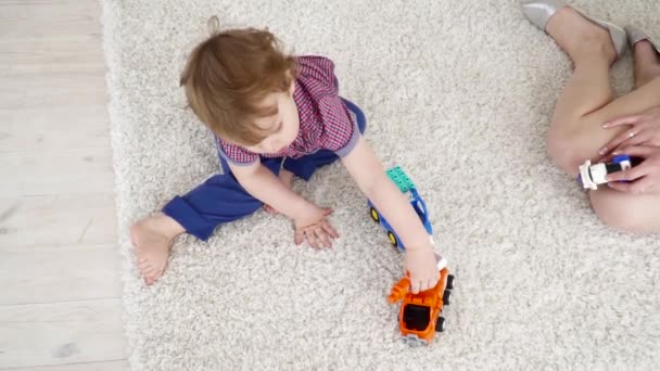 Niño jugando con los coches de juguete de cámara lenta — Vídeo de stock