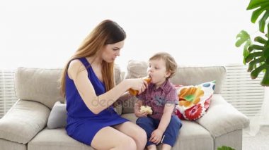 Genç anne küçük oğlu kanepede besleme