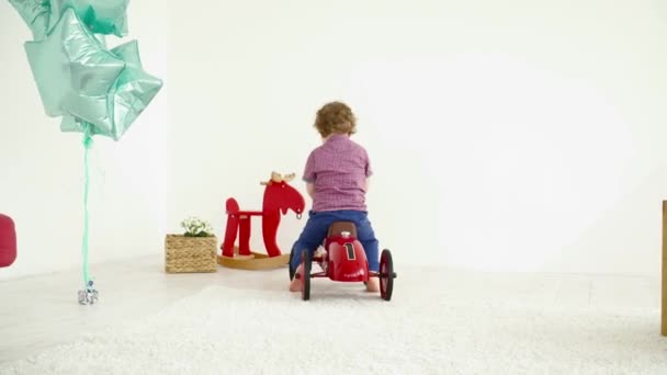 Small boy driving a toy car on the carpet — Stock Video