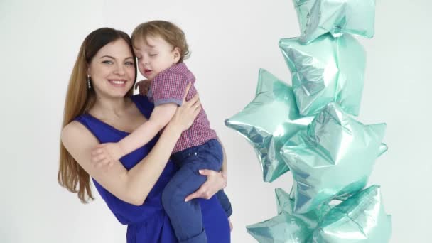 Krásná matka drží své dítě na ruce poblíž balóny — Stock video