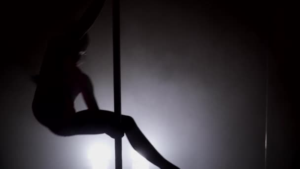 Silhouette of a woman making tricks on the pole — Stock Video