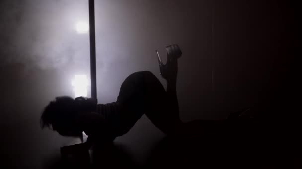 Σιλουέτα του μια γυναίκα χορεύει στο πάτωμα κοντά στο πόλο — Αρχείο Βίντεο
