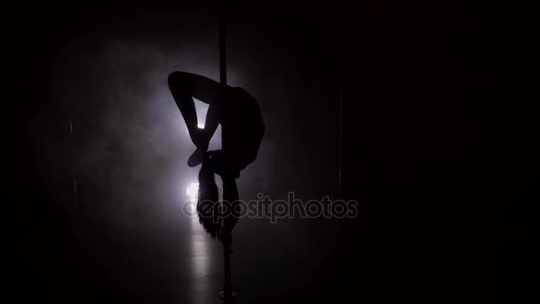 Silhouette of a slim woman dancing upside down on the pole — Stock Video