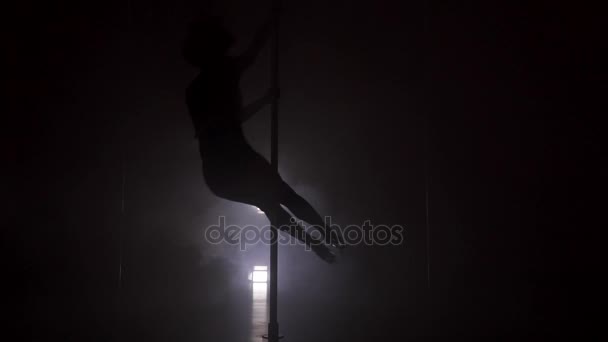 Silhouette of a young woman dancing near the pole in strip shoes slow motion — Stock Video