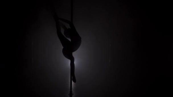 Νεαρή γυναικεία σιλουέτα χορό κοντά στο πόλο στο σκοτεινό δωμάτιο — Αρχείο Βίντεο
