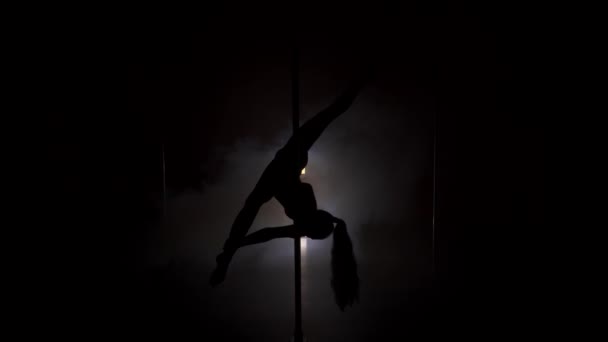 Young womans silhouette dancing near the pole in strip shoes — Stock Video