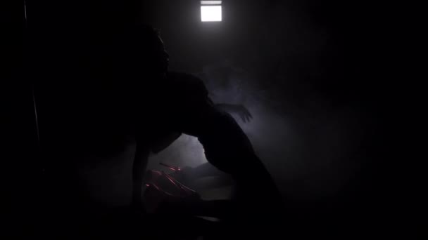 年轻苗条的女人剪影在漆黑的房间里跳舞的裙子 — 图库视频影像