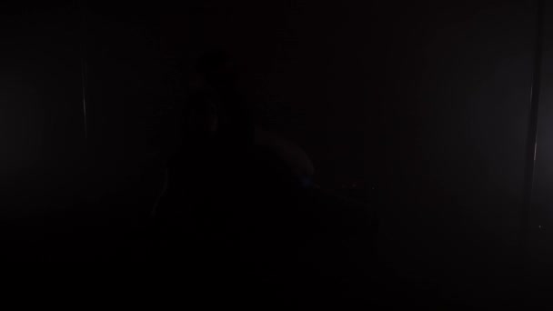 年轻苗条的女人剪影穿着短裙的在黑暗的房间里的地板上跳舞 — 图库视频影像