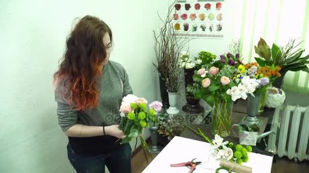 Флорист делает красивый букет в магазине — стоковое видео