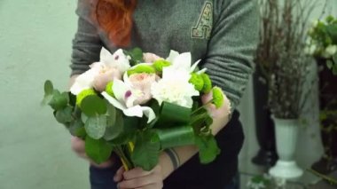 Orchinds ve gül ile güzel bir buket yapma çiçekçi kadın