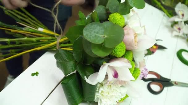 Florista mujer haciendo un hermoso ramo sobre la mesa — Vídeos de Stock