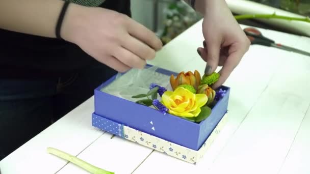 Флорист делает букет в коробке крупным планом — стоковое видео