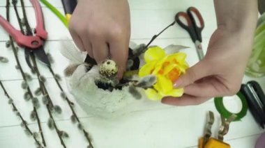 Ahşap masa üzerinde gesso tencerede bir buket yapma çiçekçi