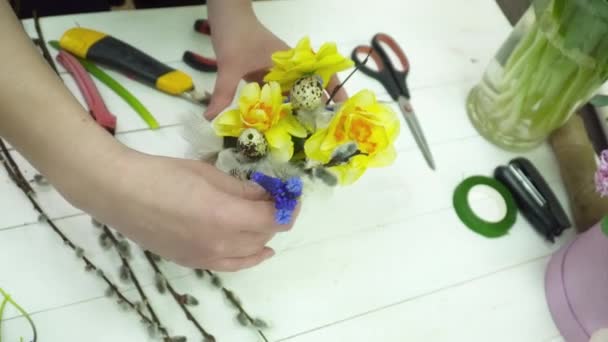 Florist making a bouquet with yellow flowers in the gesso pot — Stock Video