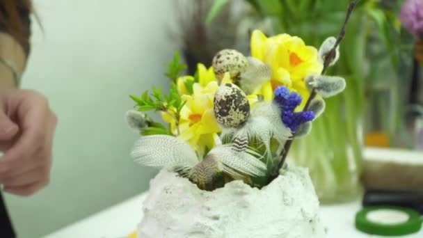 Florist making a bouquet with yellow flowers in the gesso pot in the floral shop — Stock Video