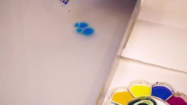 Resim yapmak için Ebru tekniği kullanarak bir sanatçı