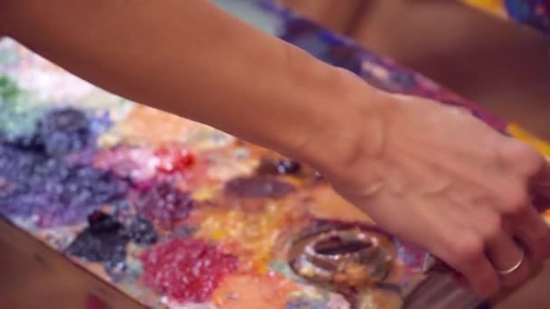 Художник, який бере фарбу і маскується на полотні — стокове відео