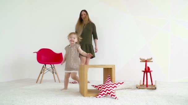 Mãe e sua bela filha correndo ao redor da sala câmera lenta — Vídeo de Stock