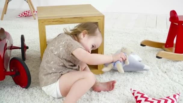 Pequena menina rastejando no chão e jogando — Vídeo de Stock