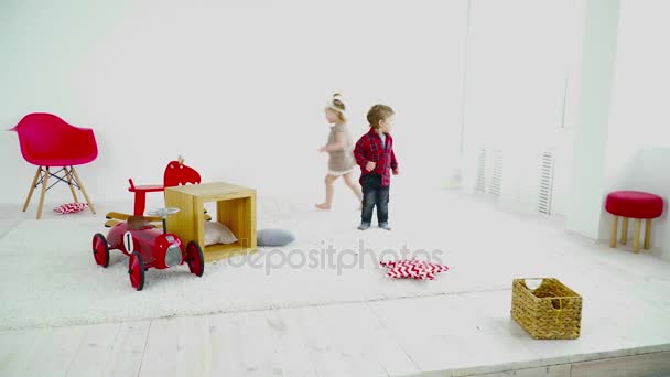 Двоє дітей біжать по кімнаті — стокове відео