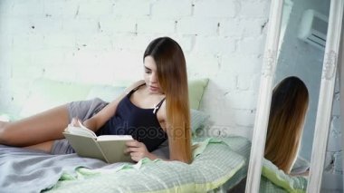 Kadın yatakta döşeme ve bir kitap okuma