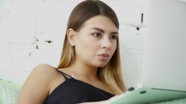 Onu laptop yatak closeup kullanan genç güzel kadın