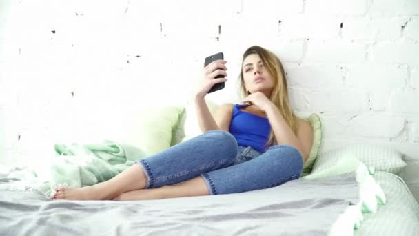 Mulher bonita fazendo selfie deitado na cama closeup — Vídeo de Stock
