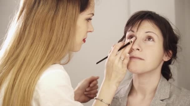 Joven maquillador aplicando base con pincel a la cara — Vídeos de Stock