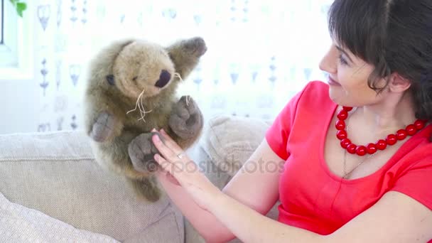 Беременная женщина сидит на диване и играет с игрушкой крупным планом — стоковое видео