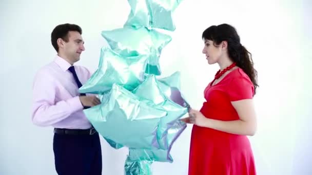Молода вагітна жінка грає з кулями зі своїм чоловіком — стокове відео