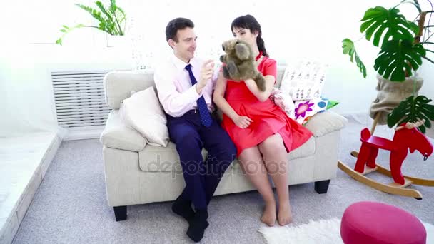 妊娠中の女性がリビング ルームのおもちゃで彼女の夫と一緒に遊んで — ストック動画