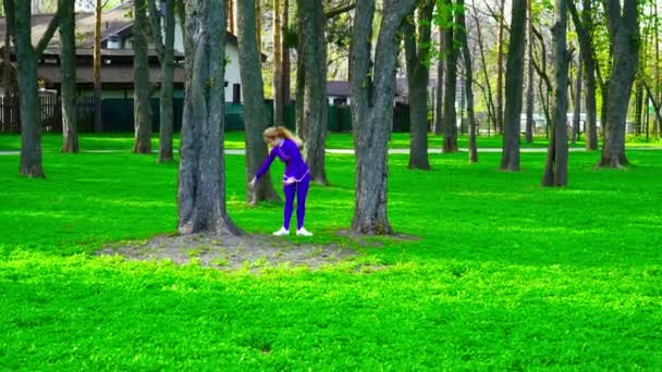 Молодой гимнаст танцует на траве — стоковое видео