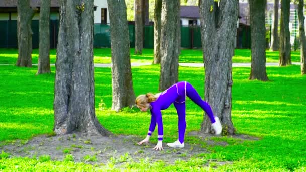 Joven gimnasta bailando y haciendo trucos en el parque — Vídeo de stock
