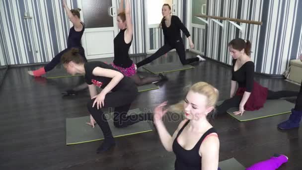 Группа стажеров, выполняющих упражнения на растяжку в танцевальном классе — стоковое видео