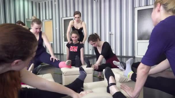 Young trainer helping her trainees to stretch — Stock Video
