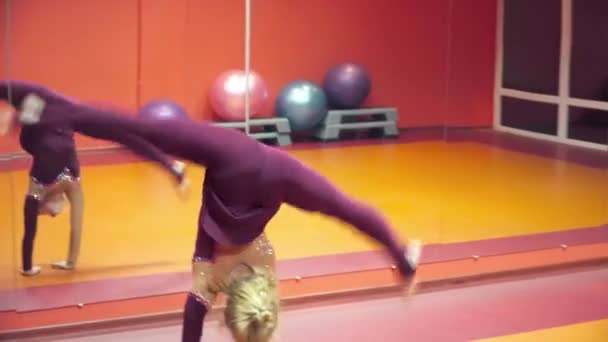 Молодая женщина делает трюки в танцевальной студии крупным планом — стоковое видео