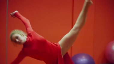 Genç jimnastikçi kadın ayna closeup kırmızı bir elbiseyle dans sınıfında dans