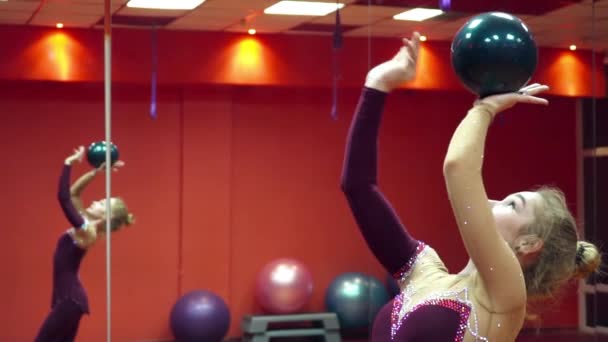 Молодая гимнастка играет с мячом замедленной съемки — стоковое видео