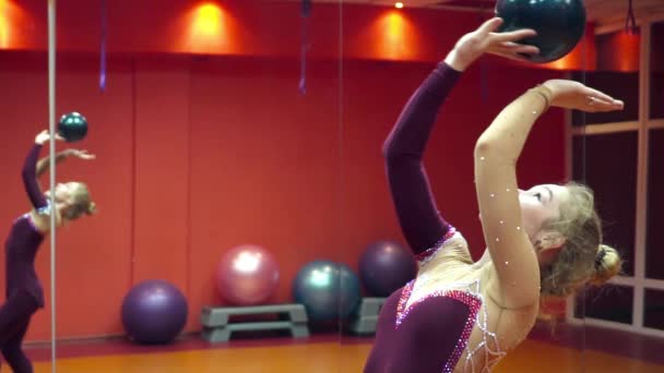 Молодая блондинка гимнастка играет с мячом замедленной съемки — стоковое видео